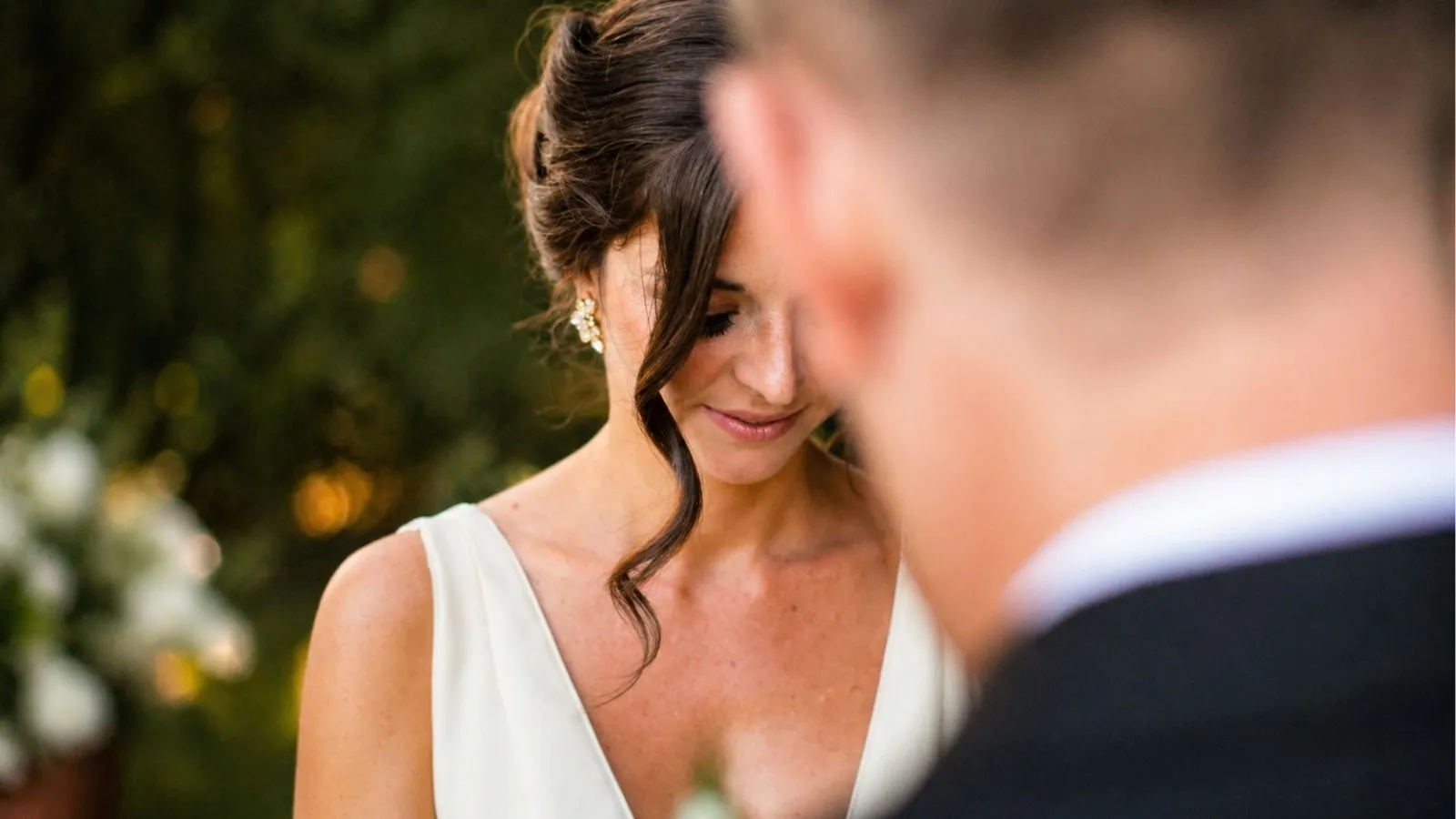 Bride looking down emotionally before reading her wedding vows