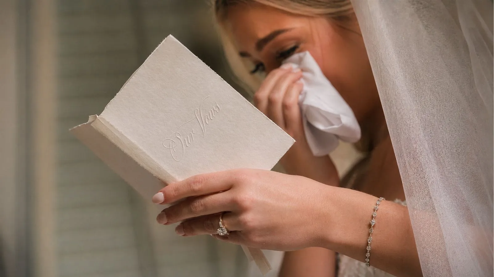 Bride reading wedding vows and wiping tears during ceremony