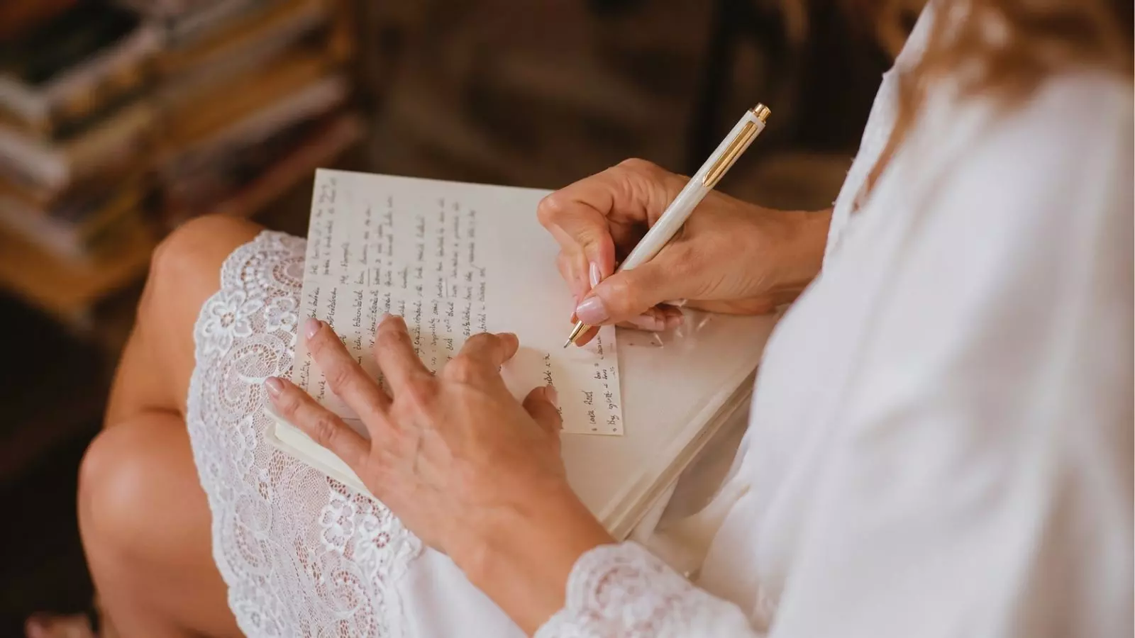 Bride writing wedding vows by hand before ceremony