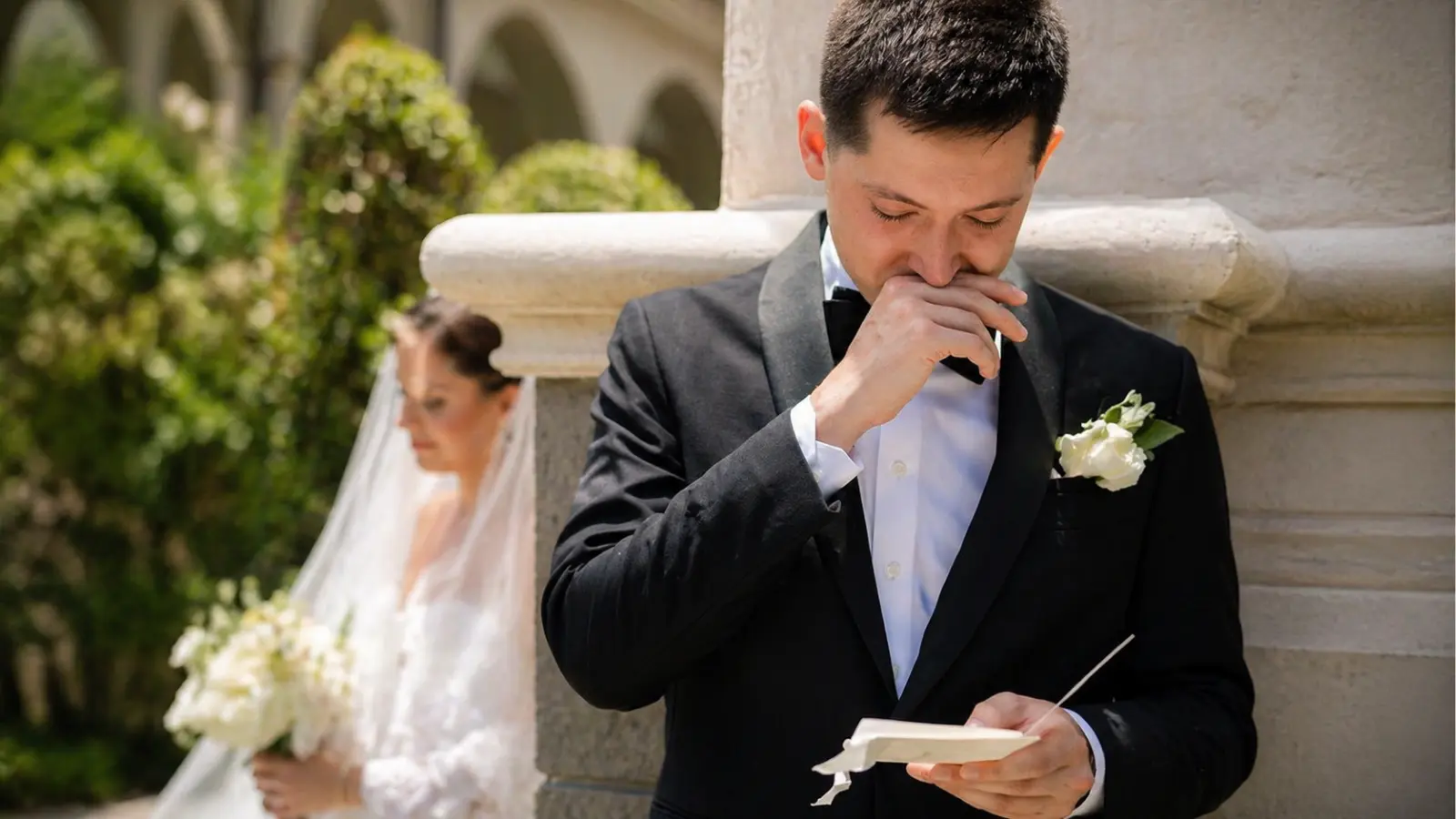 groom reading wedding vows during ceremony with bride in background