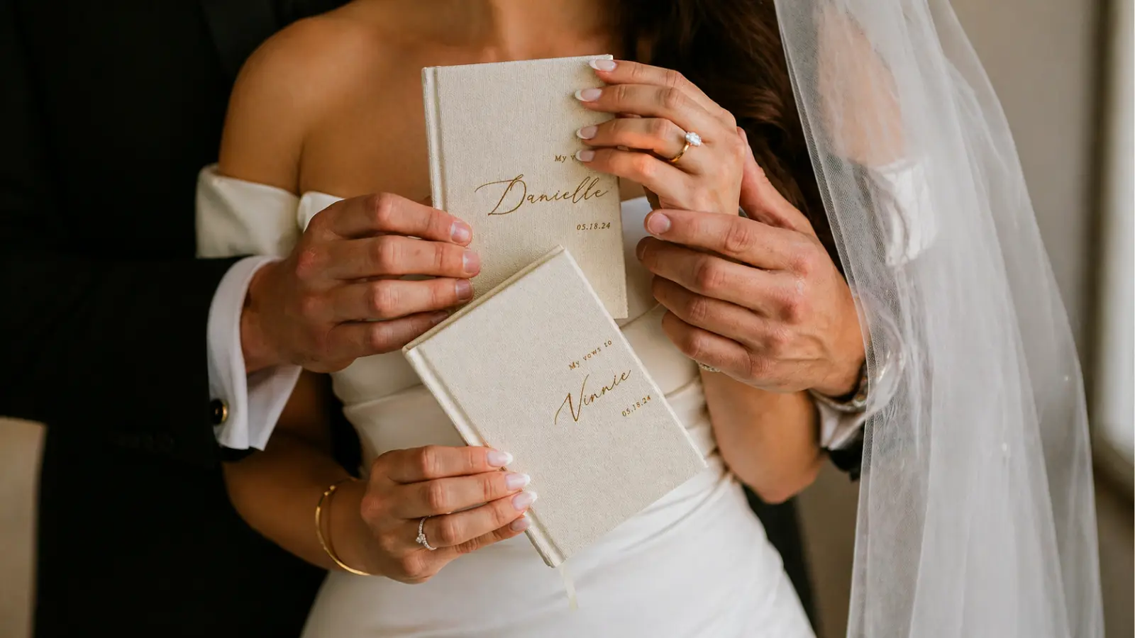 bride and groom holding personalized wedding vow books