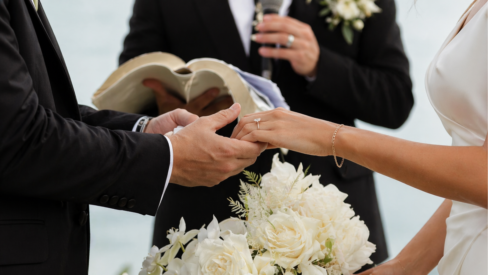 Close-up of bride and groom exchanging wedding rings during ceremony
