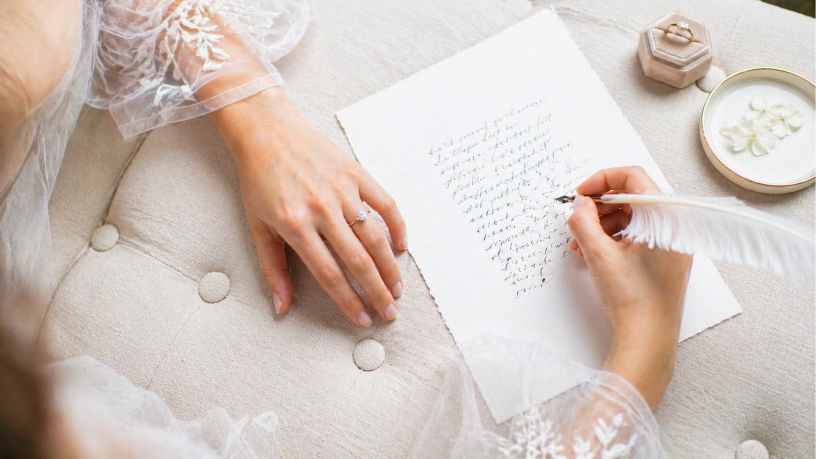 Bride writing wedding vows on textured paper with elegant details