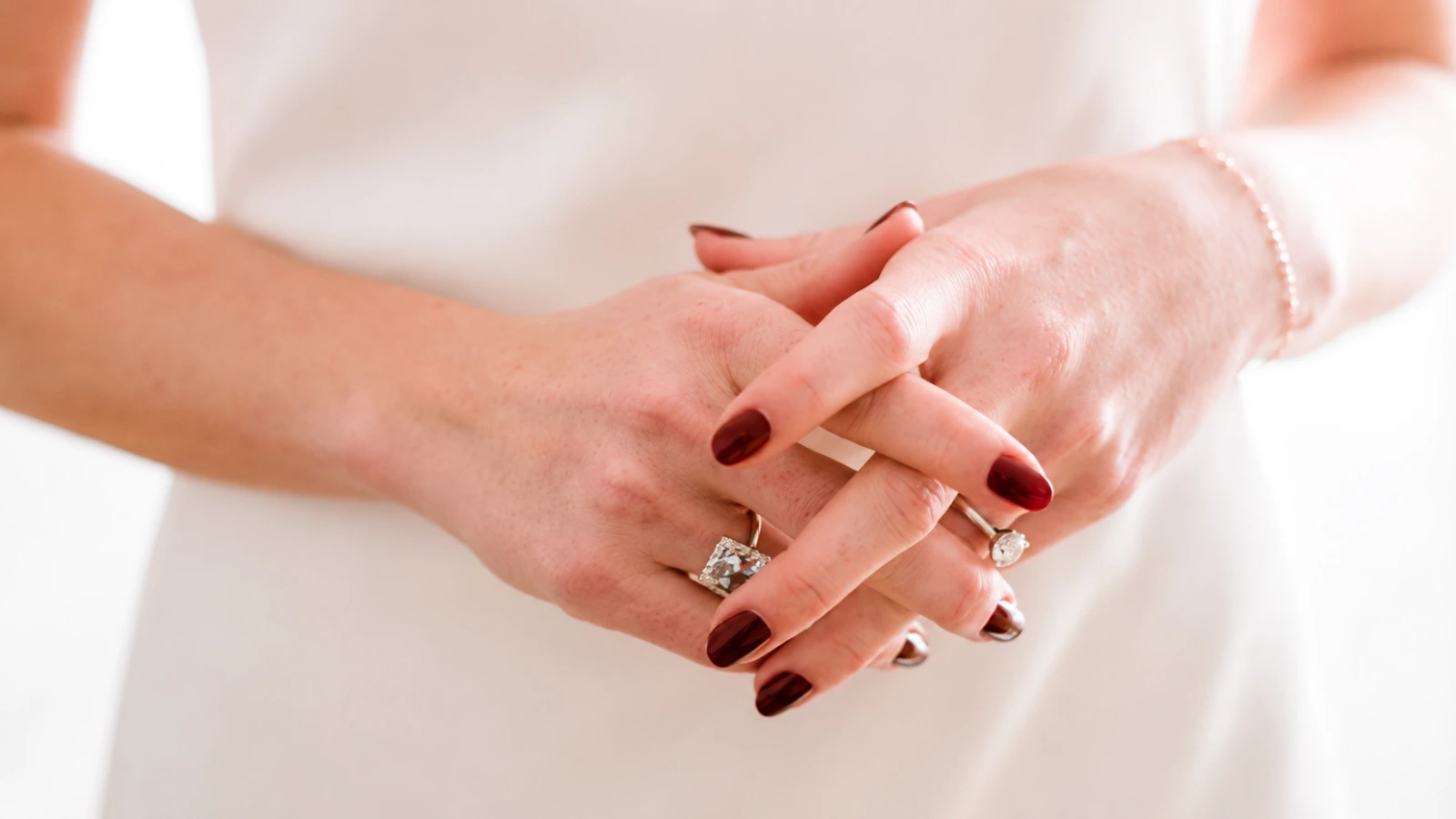 Deep burgundy wedding nails with gold rings and white orchids