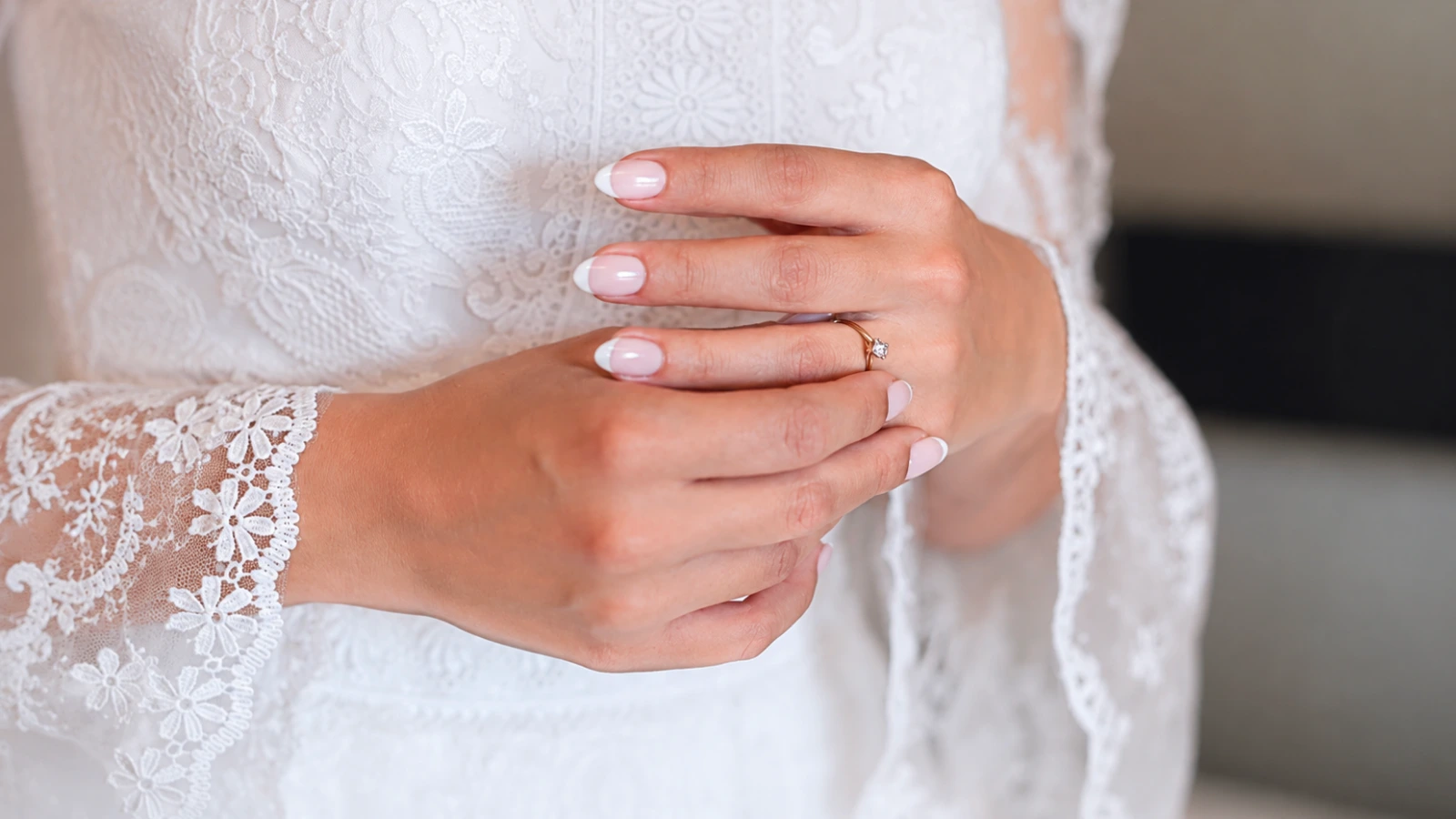 French tip wedding nails with lace bridal sleeves and elegant bridal styling