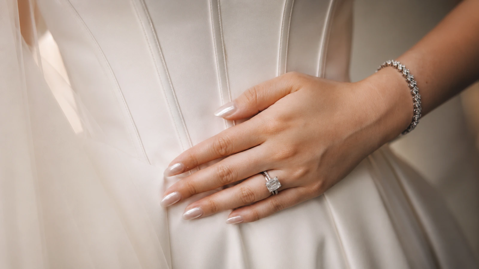 Minimal bridal wedding nails with pearl finish on a white corset dress