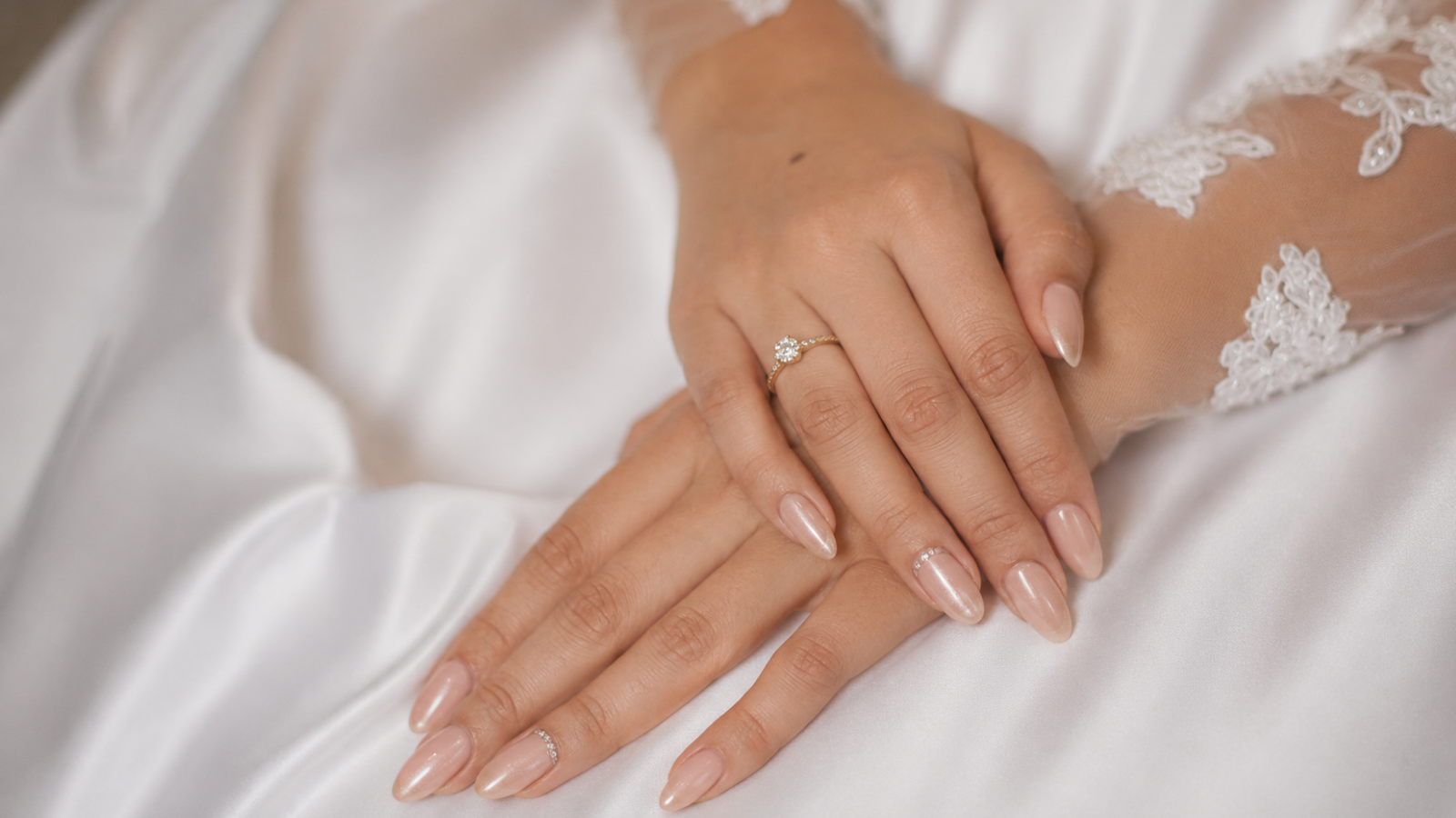 Pearlescent nude wedding nails with lace bridal sleeves