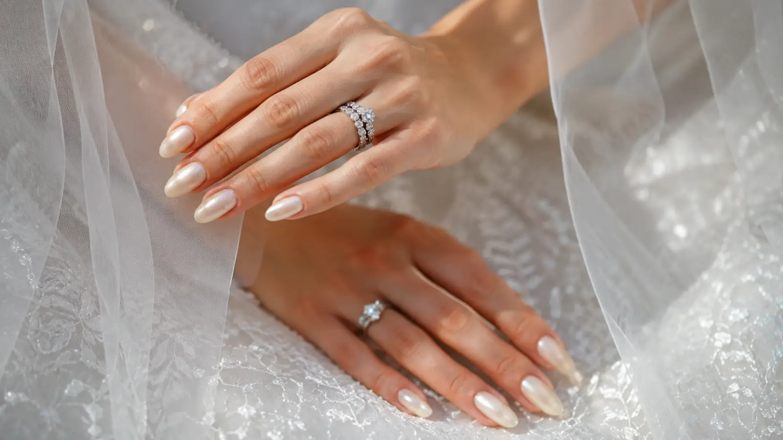 Pearl white wedding nails with bridal rings and sheer veil