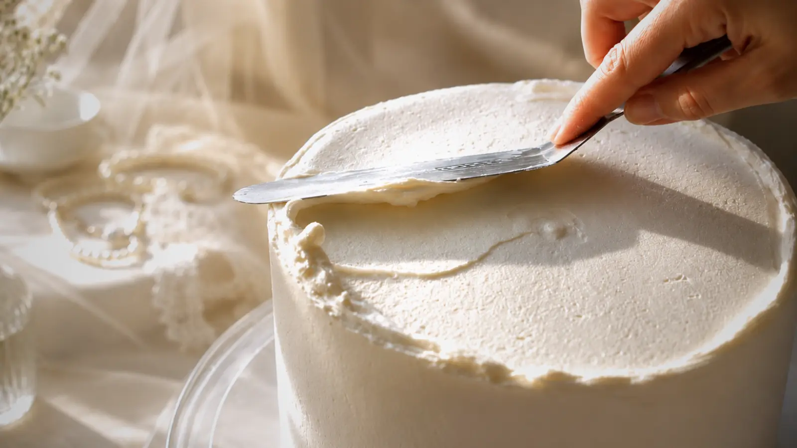Buttercream frosting being applied to cake