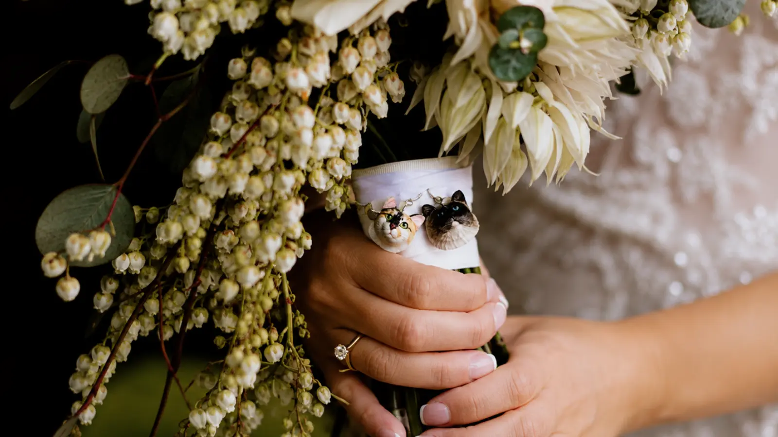 Bride holding a wedding bouquet decorated with custom cat keepsake charms
