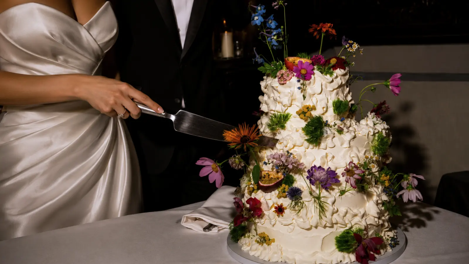 Colorful floral wedding cake with textured frosting and fresh flower decorations