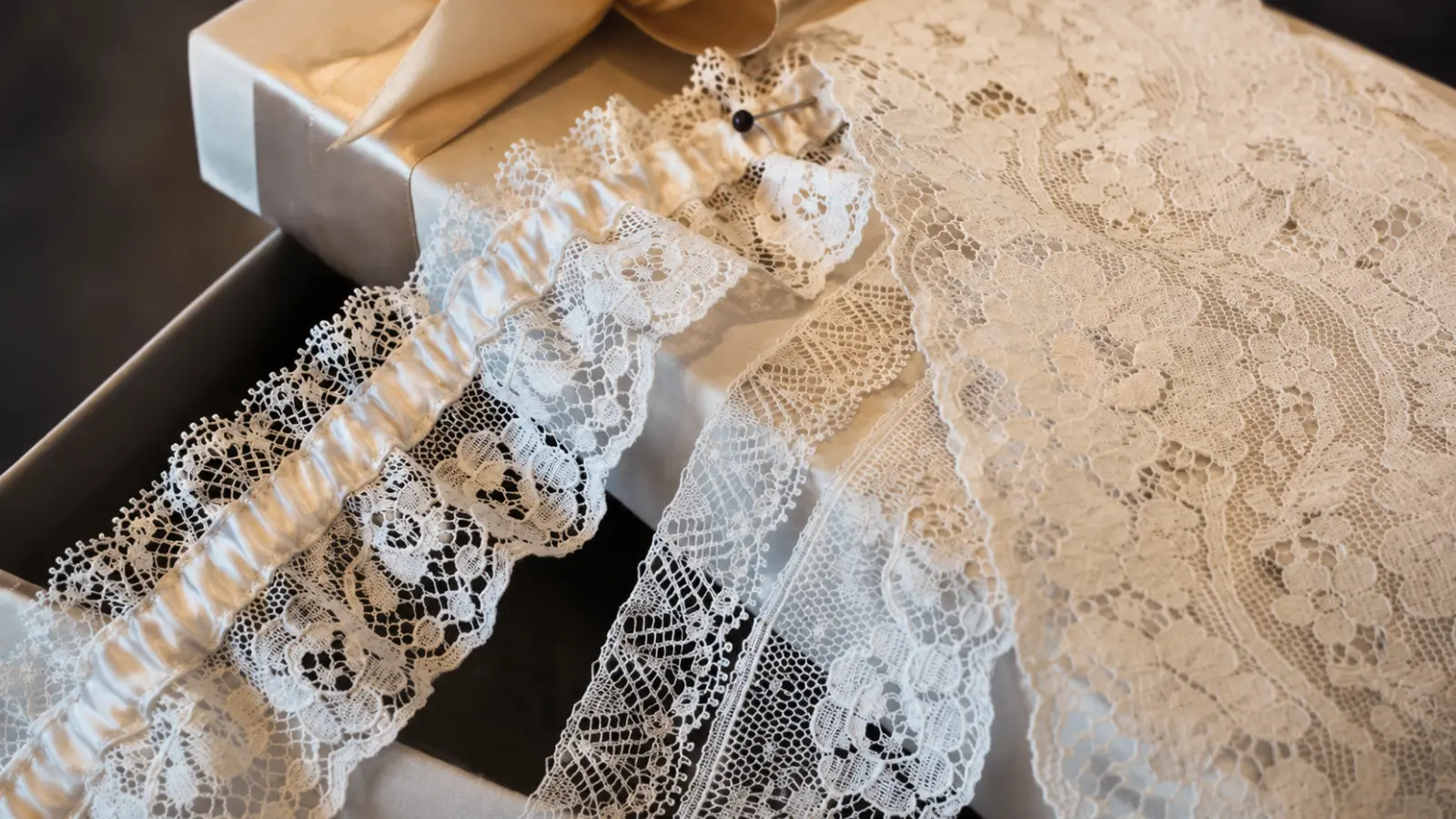 White lace wedding garter placed beside delicate bridal lace fabric to compare texture and style How to Choose a Wedding Garter