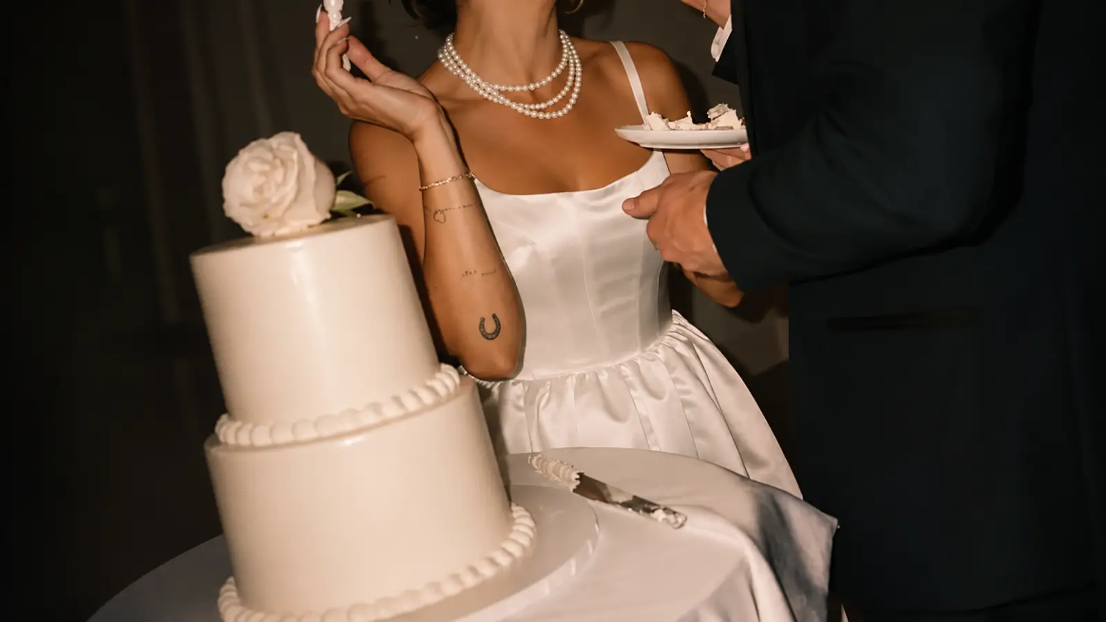 Elegant white wedding cake being served during a classy wedding reception