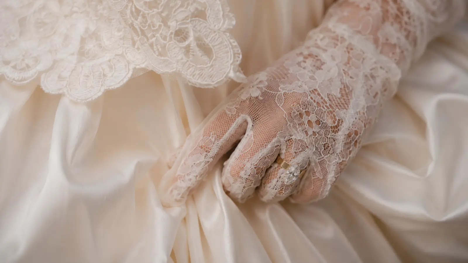 Detailed lace bridal glove fabric with floral patterns, wedding ring, and elegant bridal gown textures