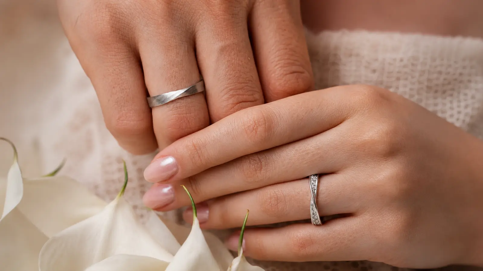Couple wearing matching wedding rings with classic metal bands and elegant bridal jewelry details.