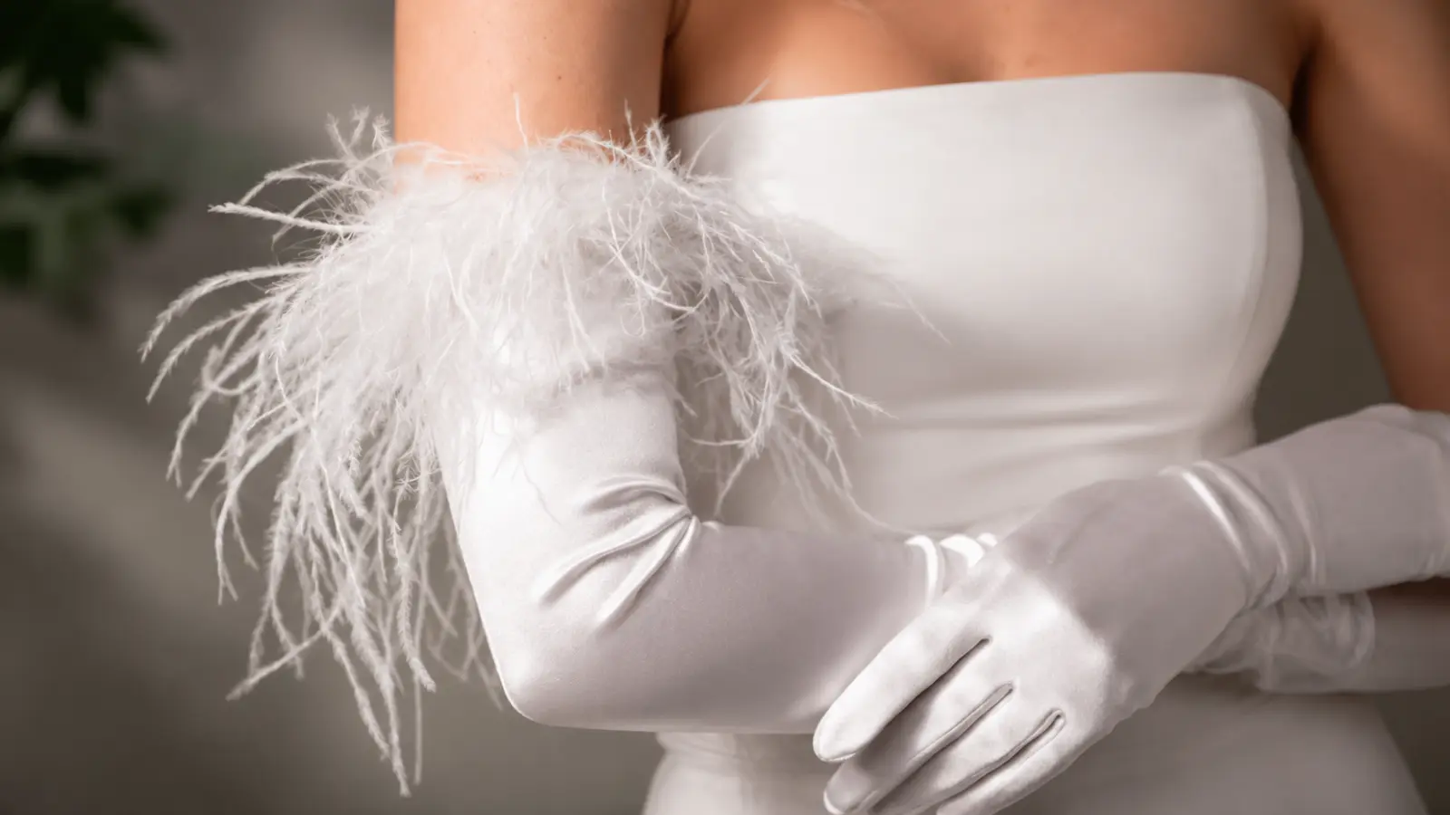 Bride wearing long opera wedding gloves with feather details, highlighting a glamorous and modern wedding accessory style
