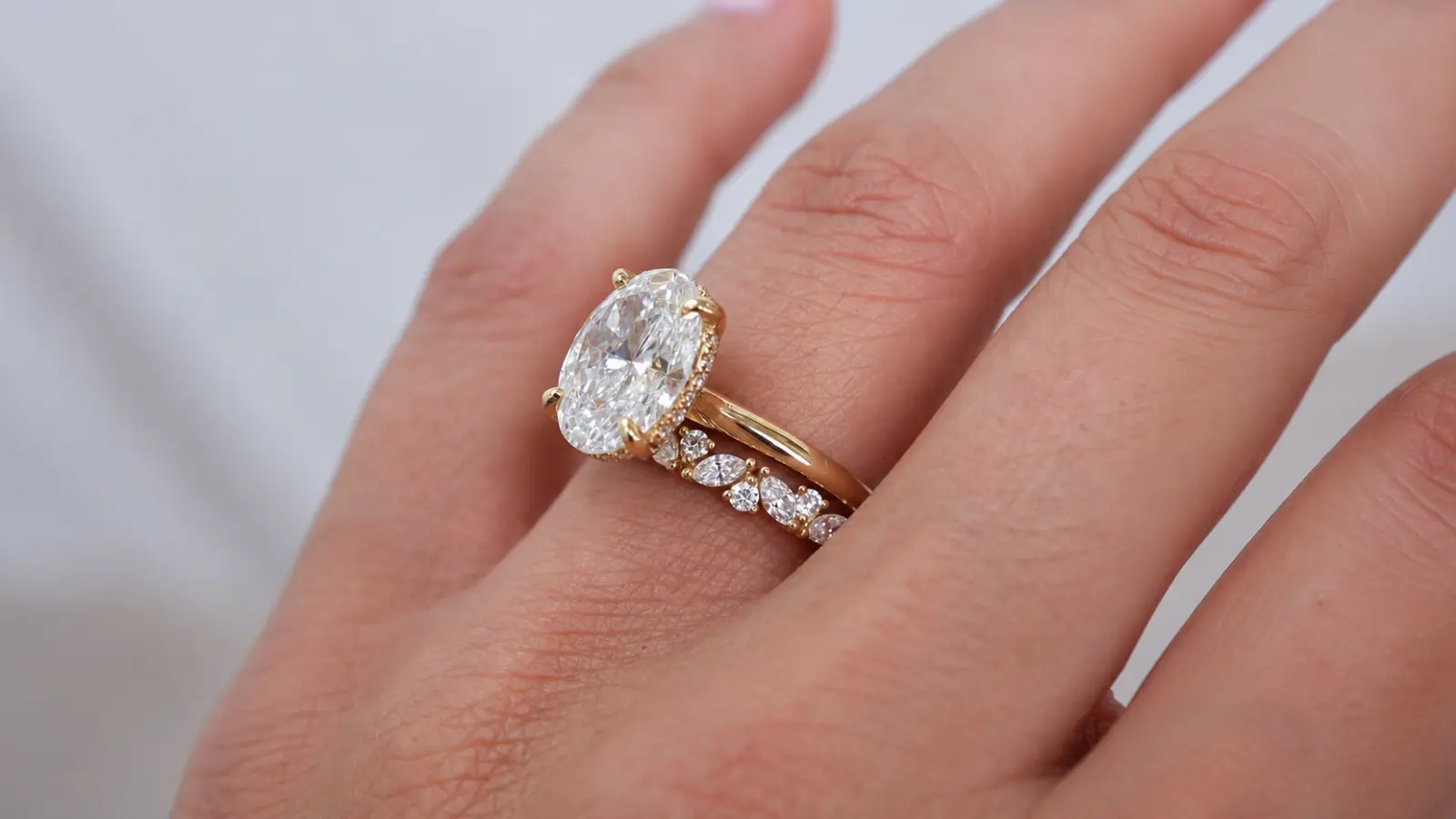 Close-up of an oval diamond engagement ring paired with a diamond wedding rings for women
