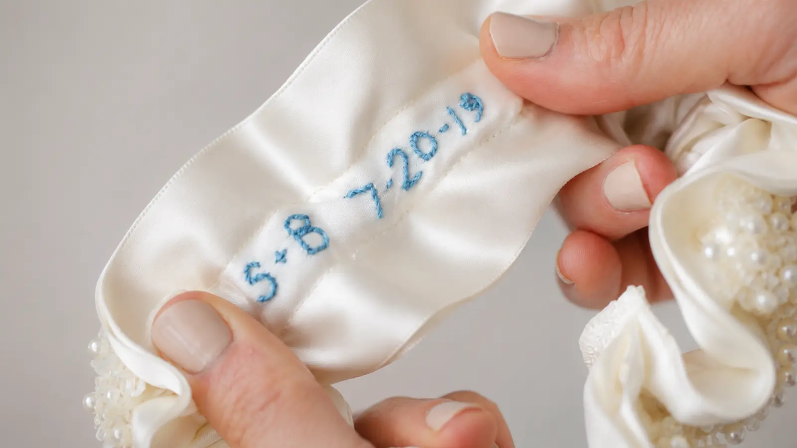 Close-up of a handmade wedding garter with an embroidered wedding date and personalized details