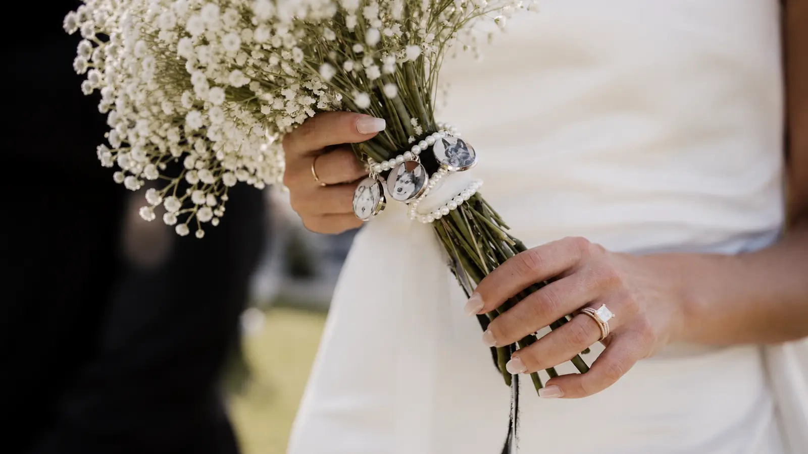 Bride holding a wedding bouquet wrapped with custom photo charms featuring beloved pets as a sentimental wedding remembrance