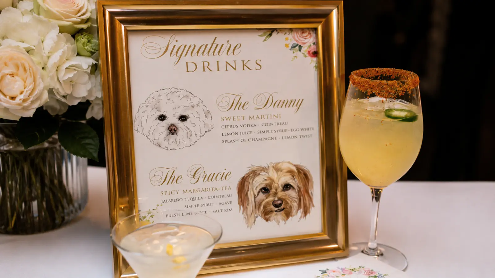Elegant wedding bar display featuring signature cocktails named after the couple's pets with custom pet illustrations in a framed menu