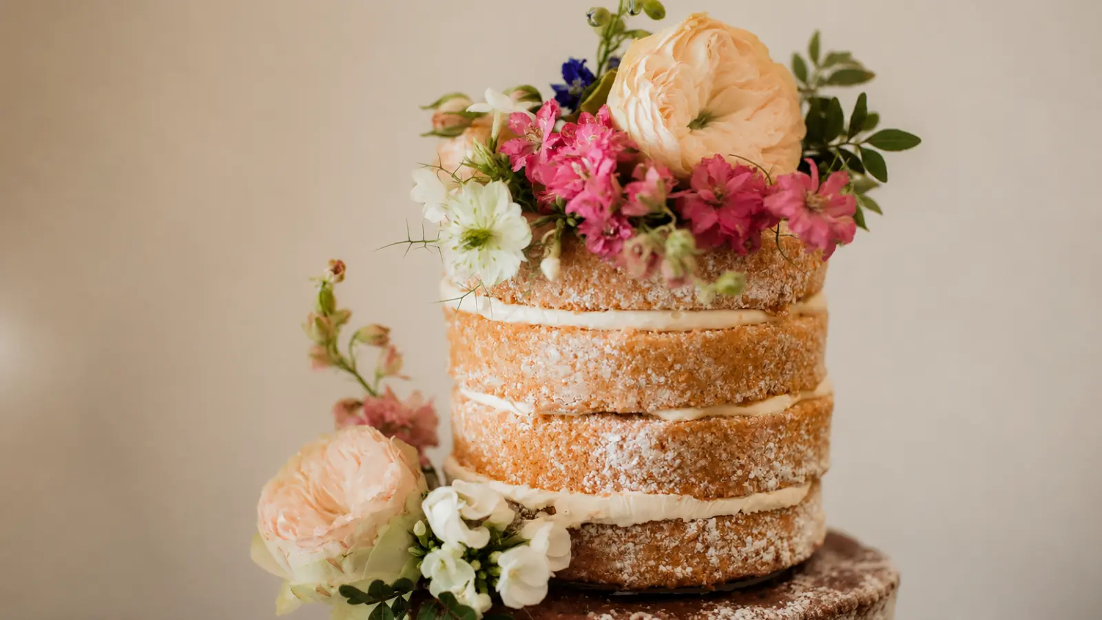 Rustic naked wedding cake with fresh flowers