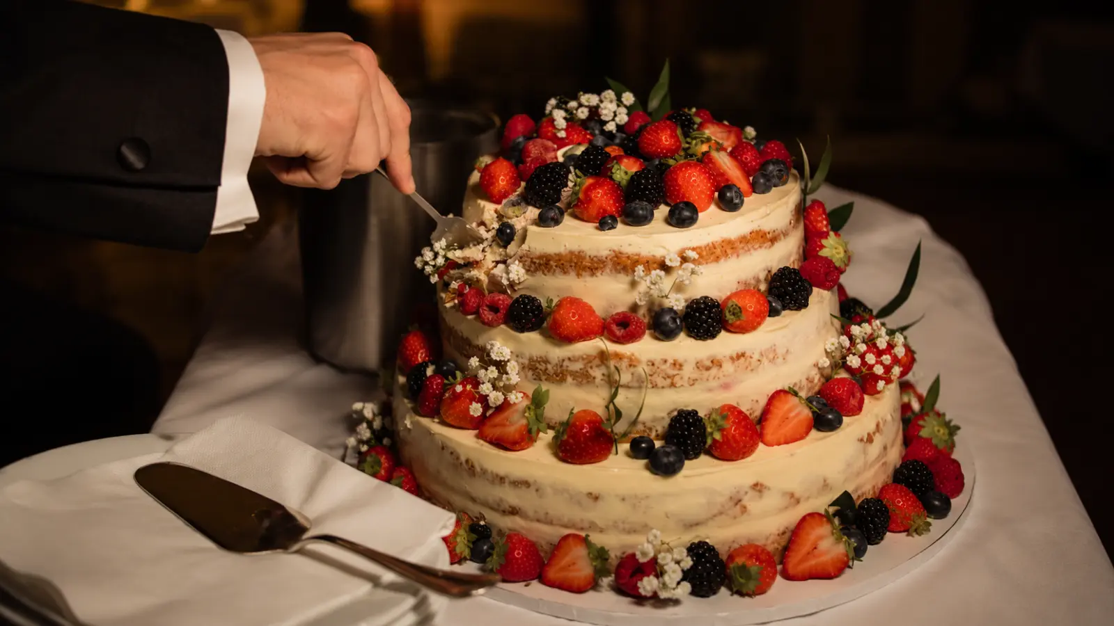 Rustic naked wedding cake with berries and simple decoration