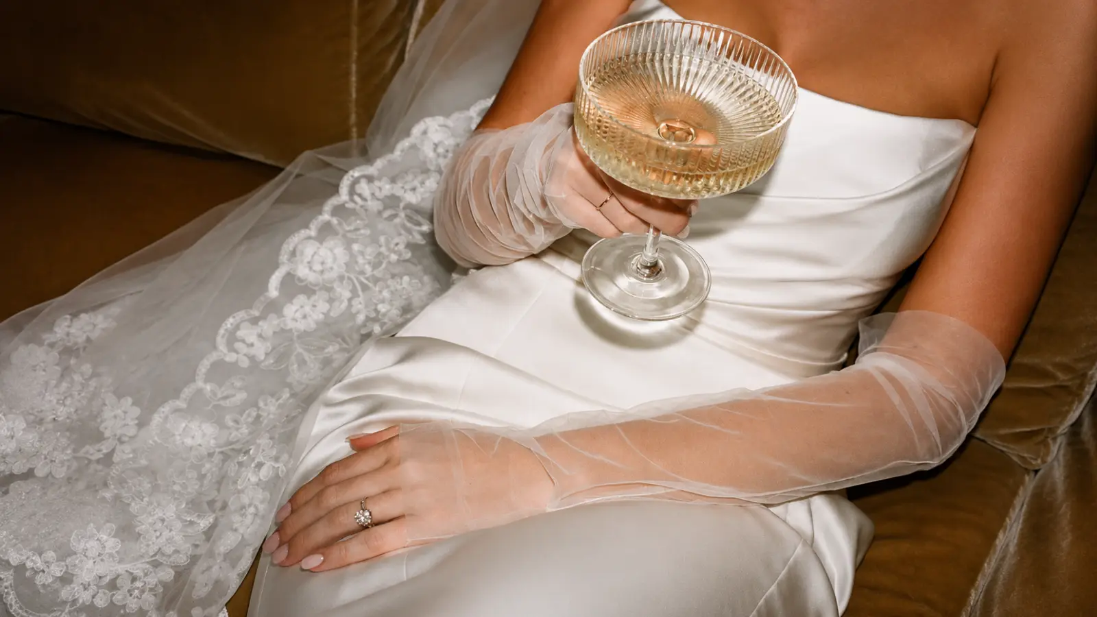 Bride wearing sheer fingerless wedding gloves with a wedding dress, featuring a soft and modern bridal accessory style