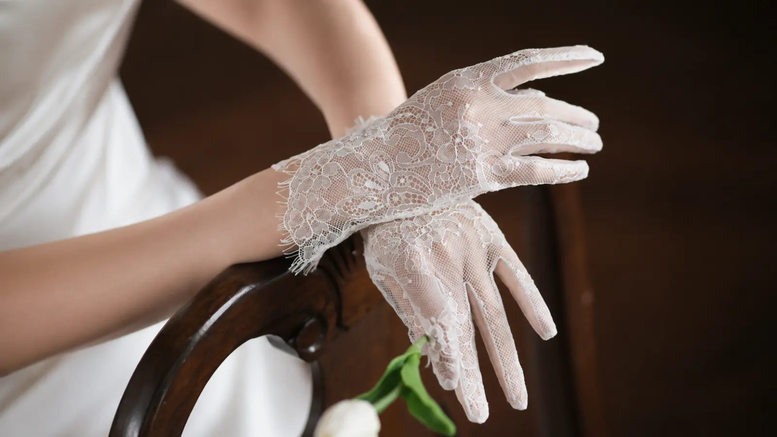 Close-up of short lace wedding gloves on a bride, highlighting vintage inspired details and romantic wedding fashion