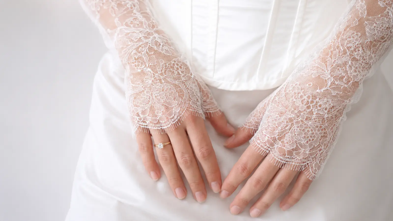Bride wearing short lace bridal gloves with a wedding ring, featuring romantic lace details and elegant wedding accessory styling
