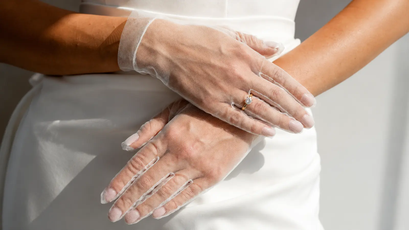 Close-up of tulle wedding glove fabric with a bridal ring, highlighting a soft sheer texture and modern wedding style Wedding Glove Fabrics