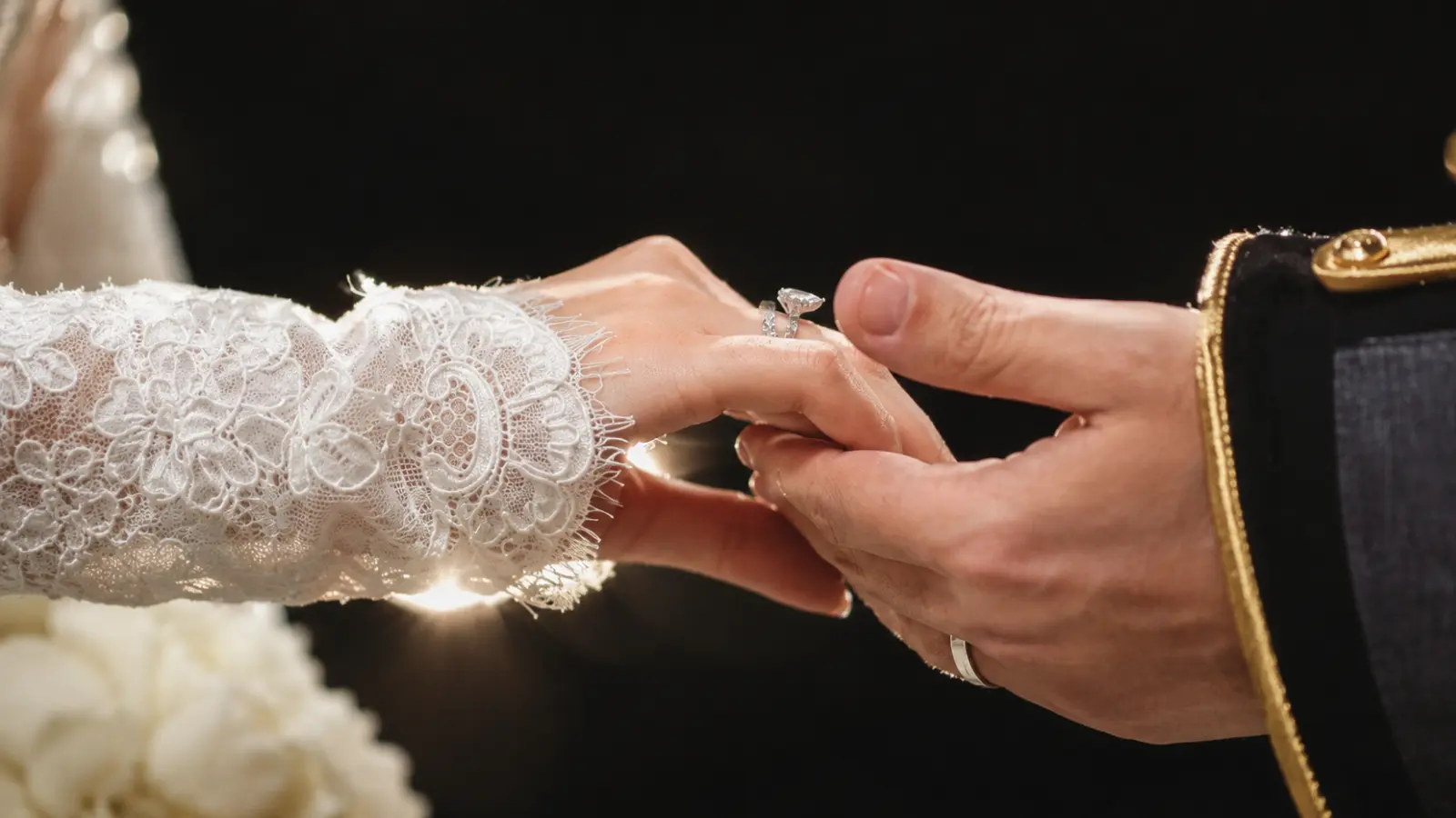Couple exchanging wedding rings during a ceremony, representing different traditions for wearing rings on the left or right hand.