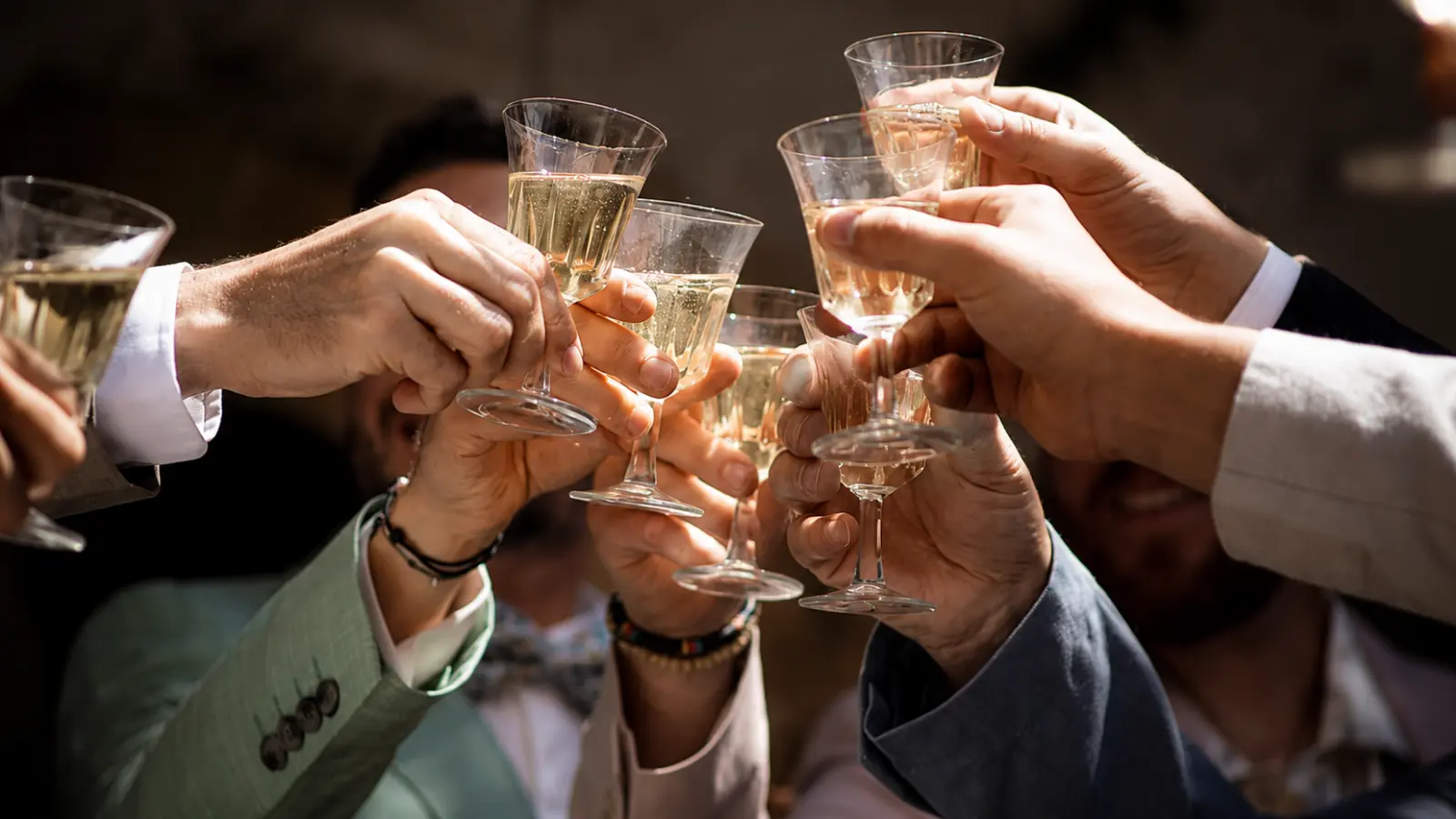 Wedding guests making a champagne toast as a modern alternative to the traditional garter toss ceremony