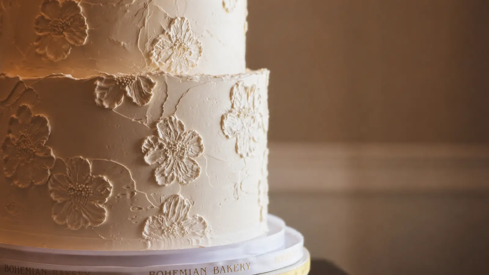 White wedding cake designs with textured floral details and elegant minimalist design