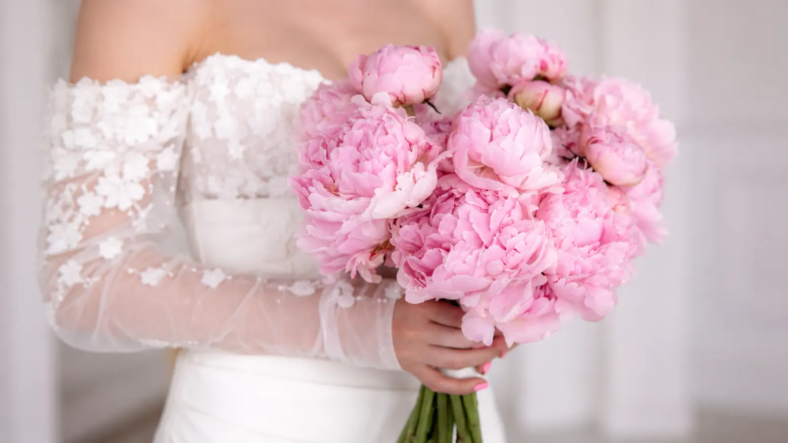 Bride holding an oversized bridal bouquet made exclusively of blush pink peonies with no filler flowers