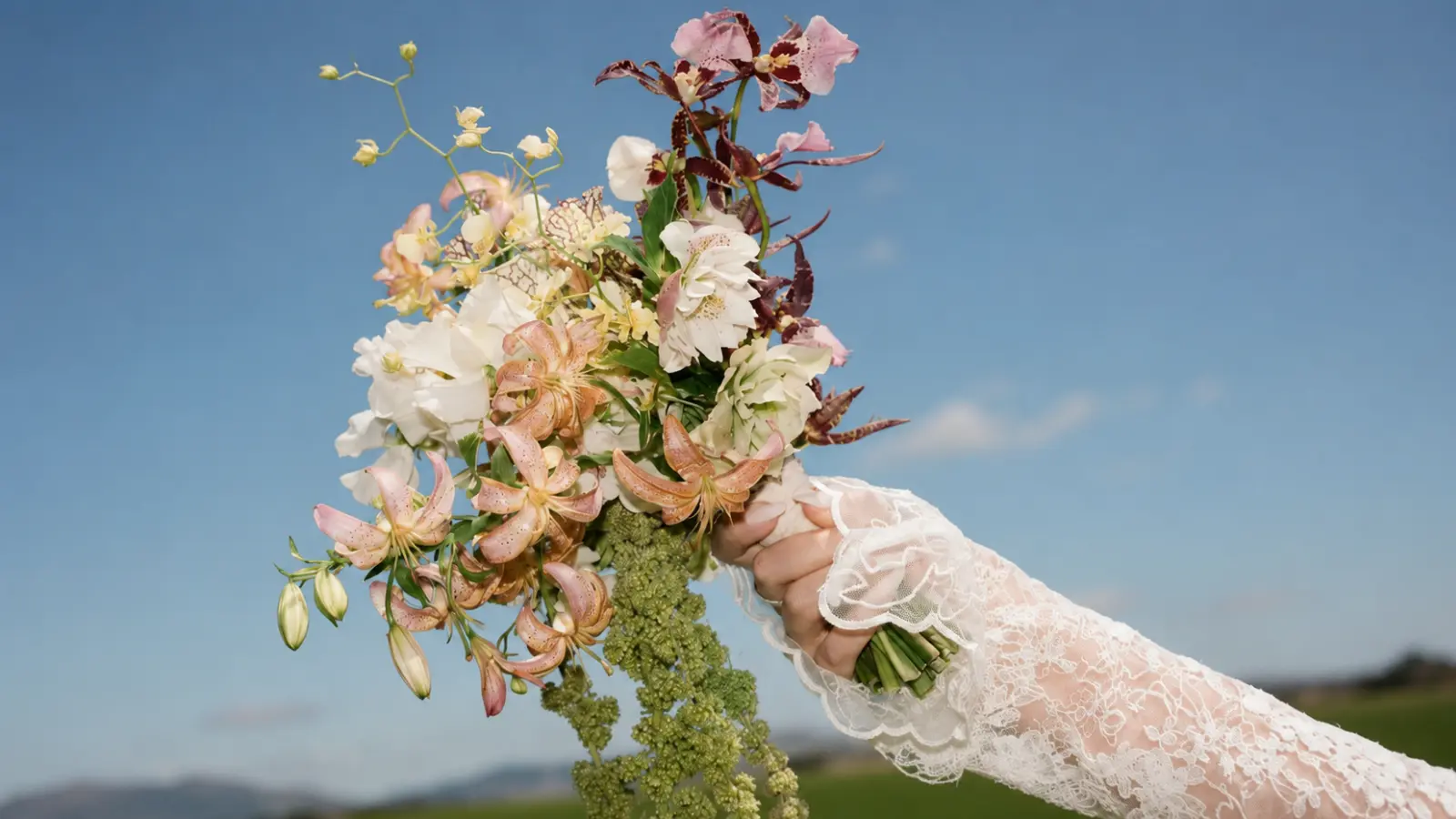 Bride holding an artistic wedding bouquet before the bouquet toss