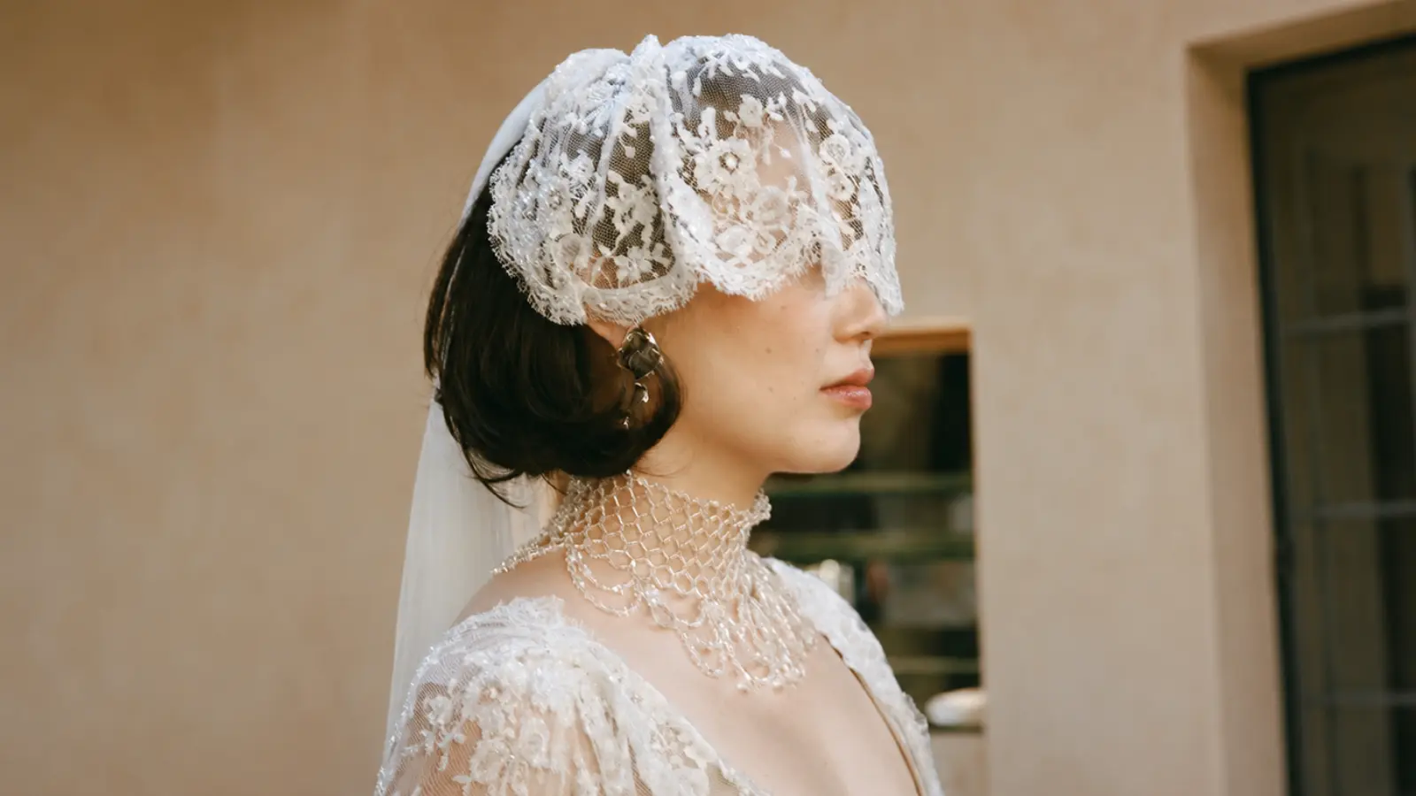 Bride wearing a lace birdcage wedding veil that covers part of the face, showing the shortest and most iconic vintage wedding veil style
