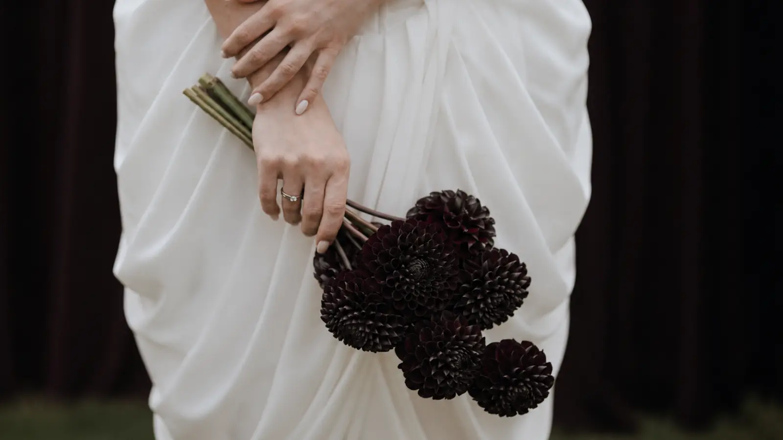 Bride carrying a black dahlia wedding bouquet