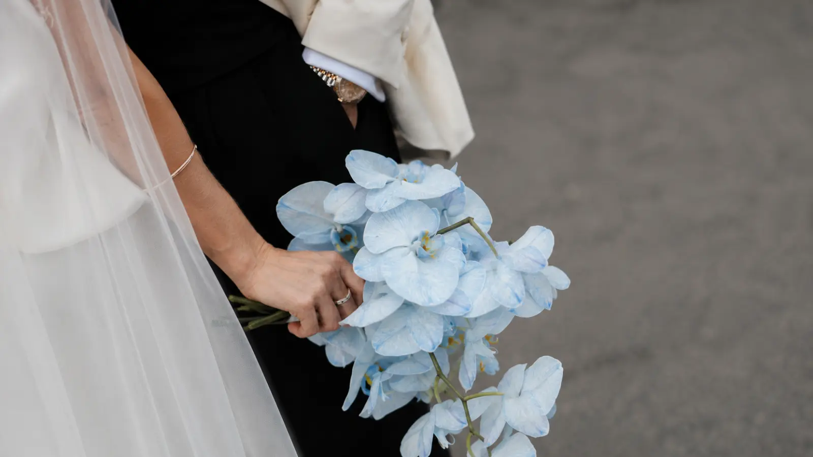 Bride holding a pastel blue orchid wedding bouquet