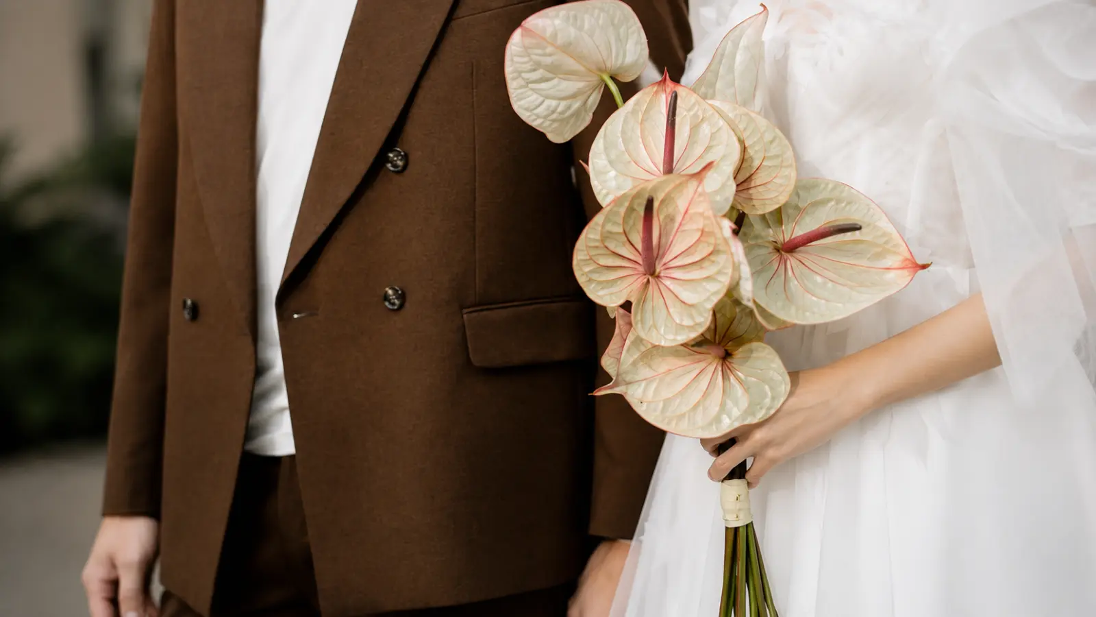 Bride holding a modern artificial wedding bouquets made with blush real-touch anthuriums