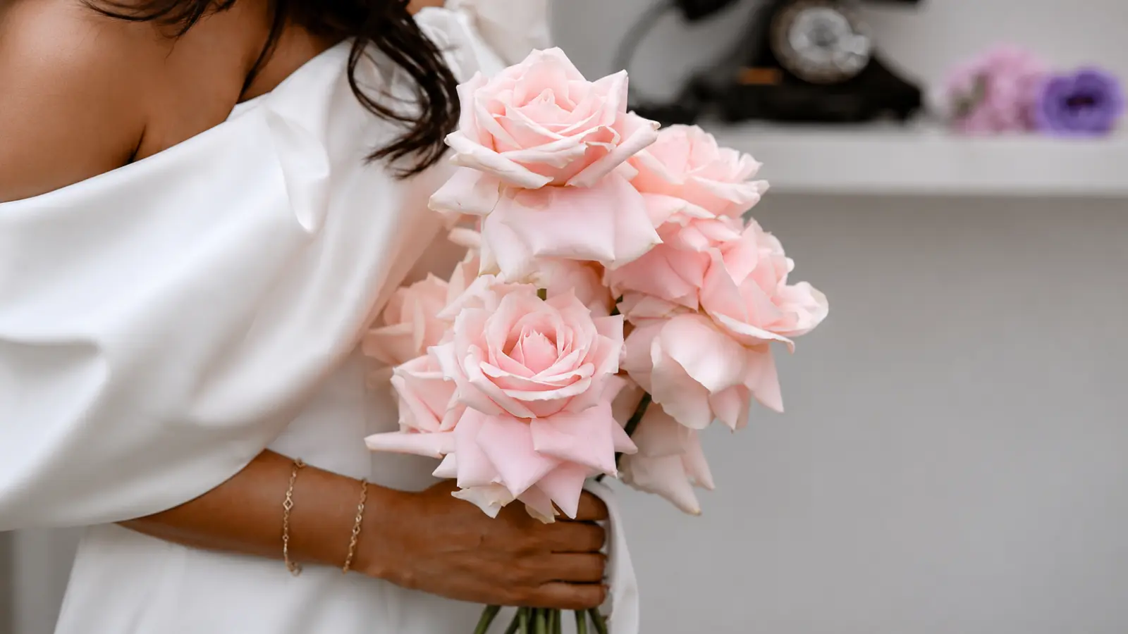 Bride holding a blush pink rose wedding bouquet featuring soft pastel blooms and an elegant romantic design