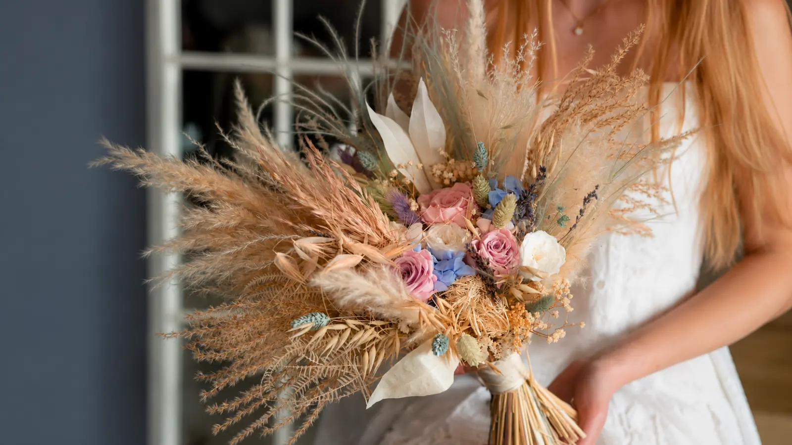 Boho dried flower wedding bouquet featuring pampas grass preserved roses and natural dried botanical elements