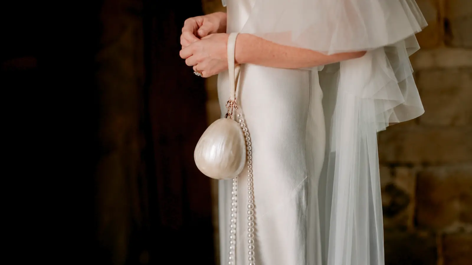 Bride carrying a pearl handbag as an alternative to a wedding bouquet