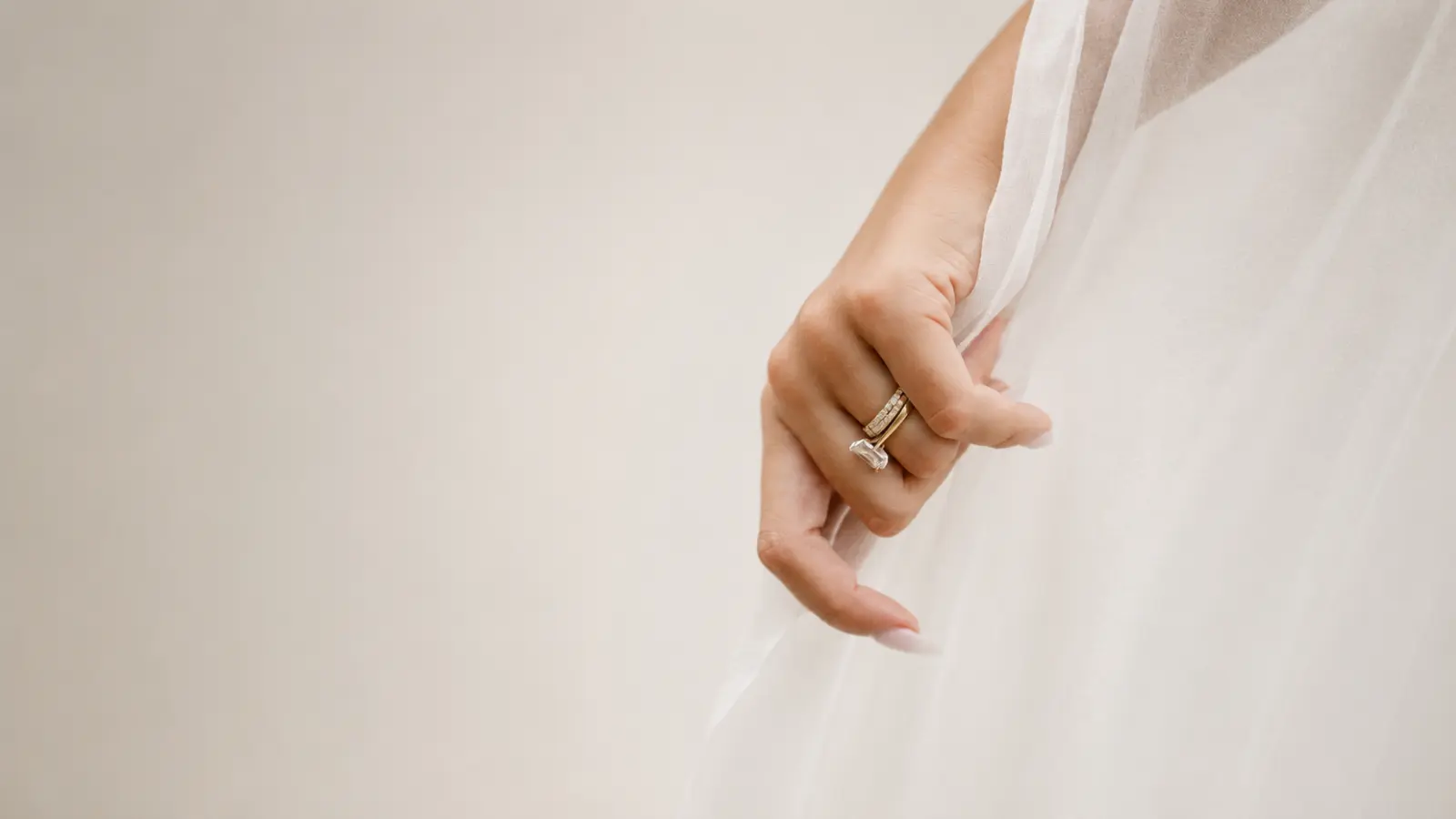 Bride holding a soft tulle wedding veil that demonstrates its lightweight and sheer material Wedding Veil Materials