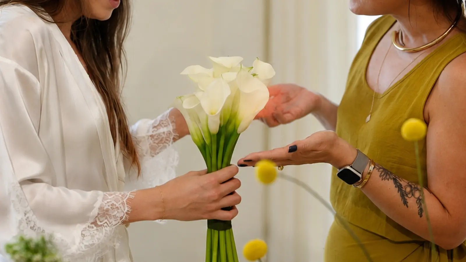 Bride consulting with a florist while holding a white calla lily wedding bouquet