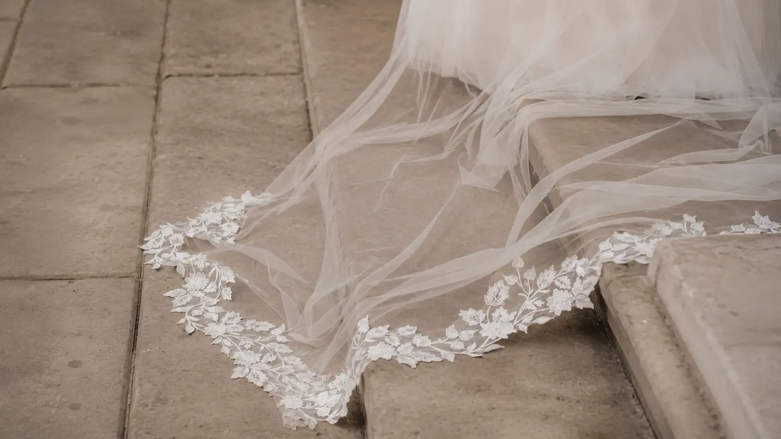Cathedral wedding veil with a long embroidered lace train extending behind the bride, demonstrating the longest wedding veil length