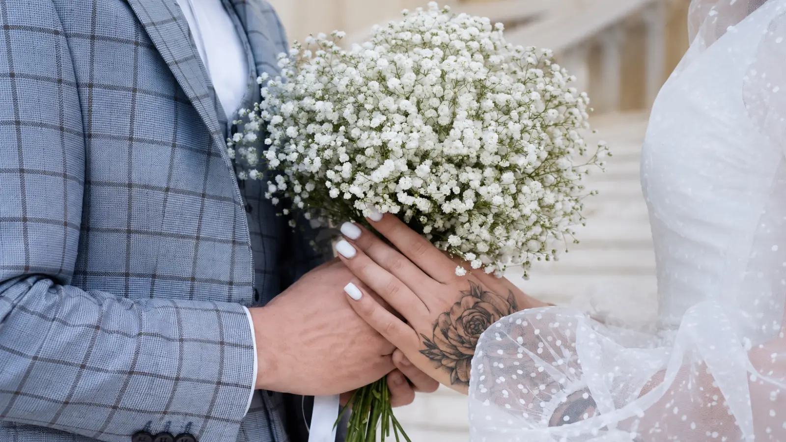 Close-up of a bride and groom holding a lush baby's breath wedding bouquet with tiny white flowers Baby's Breath Wedding Bouquets