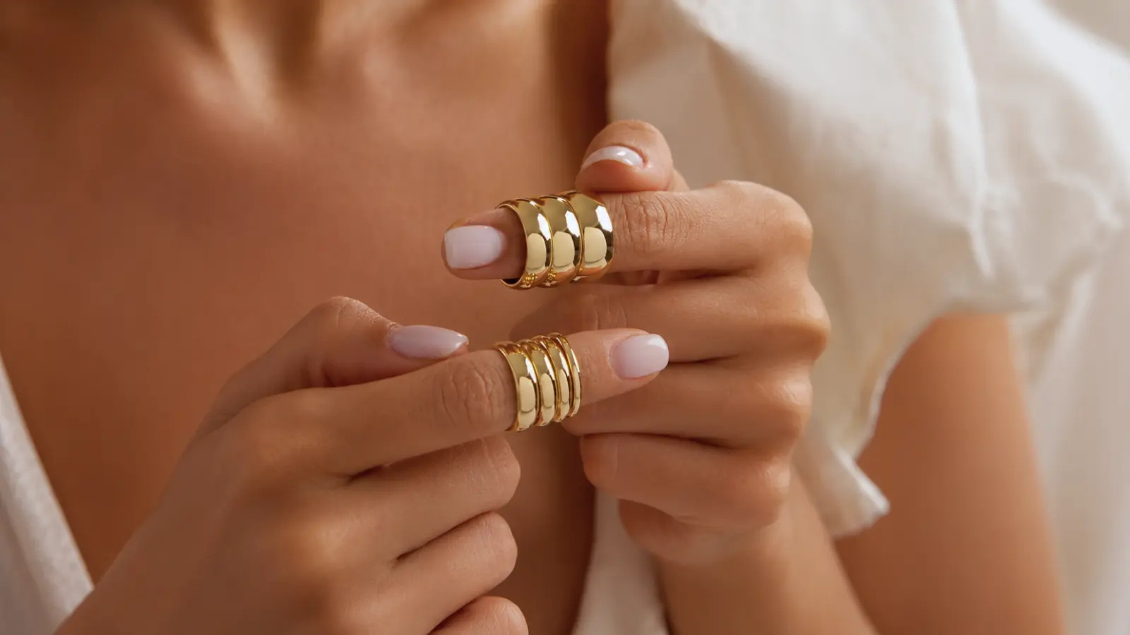 Hands holding several classic gold wedding bands in multiple widths to compare timeless wedding ring styles and proportions Classic Wedding Rings