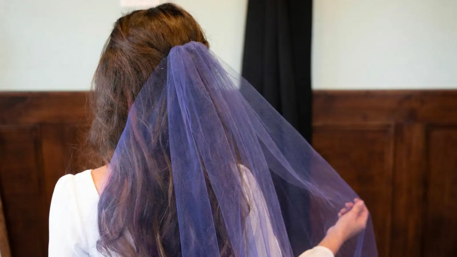 Bride wearing a purple wedding veil, showcasing a modern alternative to traditional white veils with soft tulle and a unique bridal style