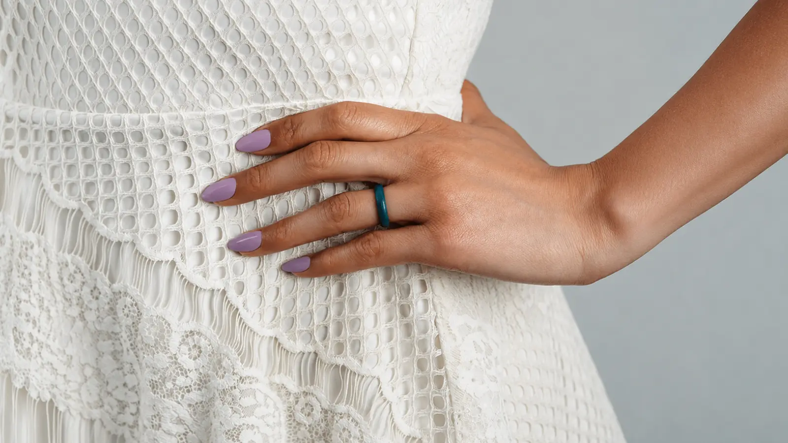 A close-up of a hand wearing a teal silicone wedding rings with a casual outfit, showcasing a lightweight and flexible alternative to metal bands