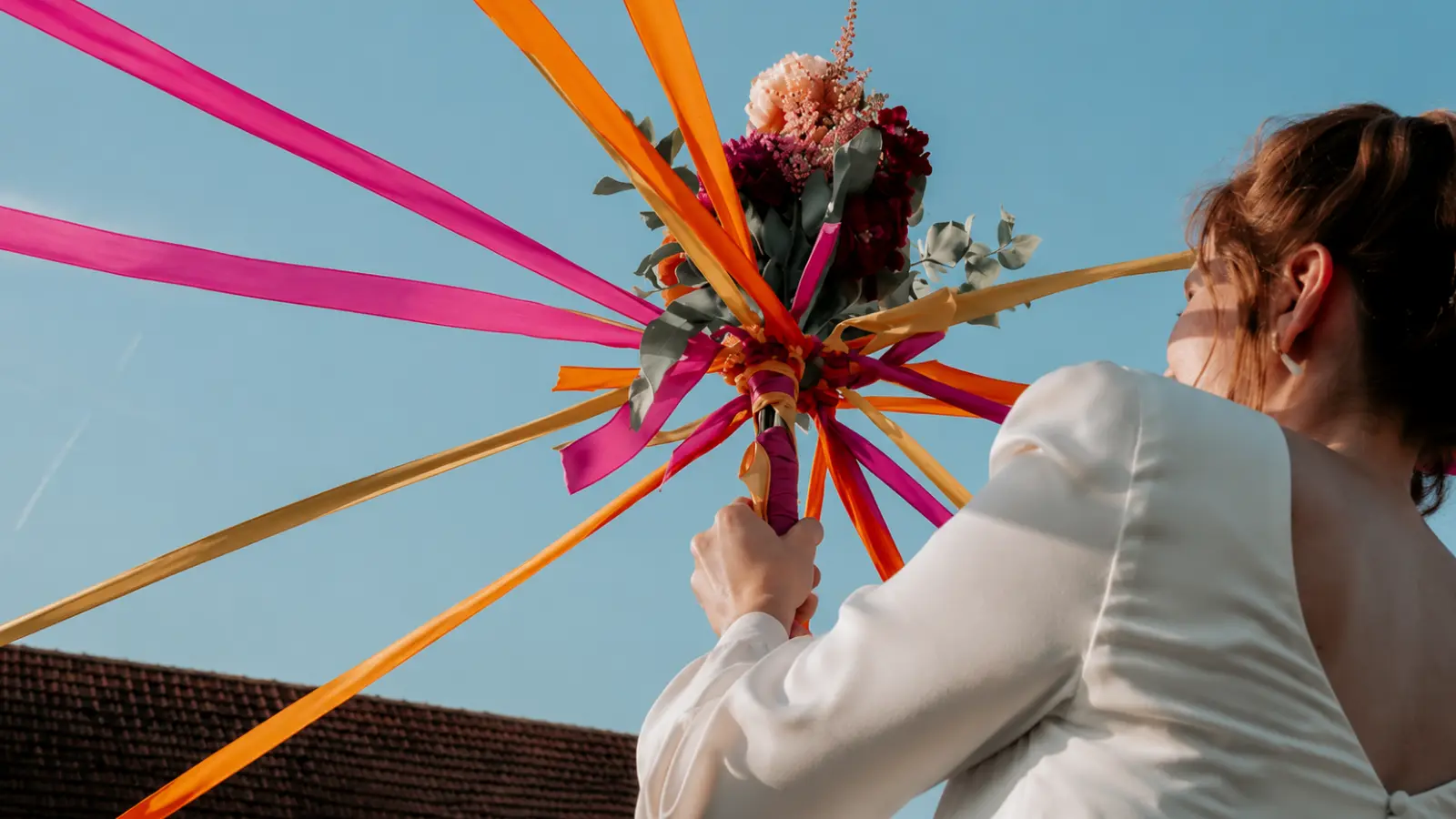 Bride playing the wedding bouquet ribbon game instead of a bouquet toss